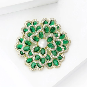 Nahaufnahme der Perlenblumen-Brosche mit olivgrünen Zirkon-Blütenblättern und Gold-Details