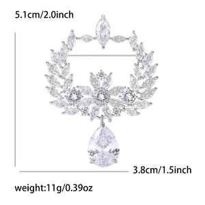 Macro detail of olive branch brooch with clear cubic zirconia and pear-cut pendant