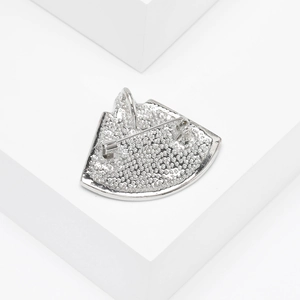 Gros plan du dos d'une broche fœtus vintage avec surface texturée et fermoir à épingle sûr