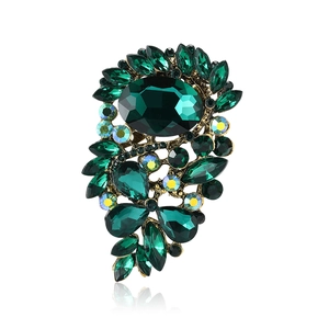 Elegant vintage gold alloy brooch featuring large dark green crystals and rhinestones