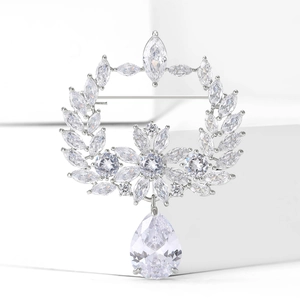 Elegant olive branch wreath brooch in silver metal with sparkling marquise cut crystals