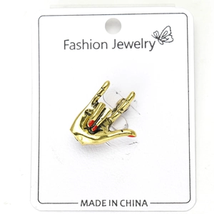 Detailed macro view of vintage gold gesture brooch with red nail polish detail on a card