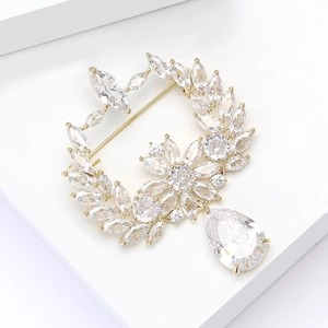 Detail of elegant olive branch brooch with brilliant cubic zirconia and teardrop pendant