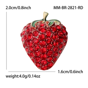 Broche fraise chic avec strass rouges et feuille émaillée verte sur base dorée