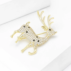 Broche renne dorée avec zircons étincelants et délicates taches noires sur fond blanc