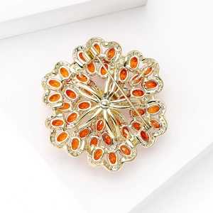 Rückansicht der goldenen Blumenbrosche mit filigraner Hohltechnik und Sicherheitsnadel