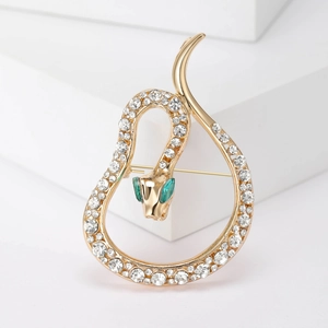Luxurious gold snake brooch featuring sparkling rhinestones and green emerald eyes