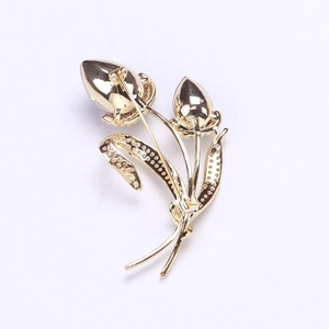 Détail de la fermeture à épingle au dos d'une luxueuse broche tulipe en métal doré
