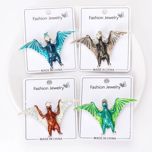 Detail view of four colorful pterodactyl brooches on white fashion jewelry cards