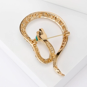 Luxurious gold-plated snake brooch with sparkling crystals and a green gemstone eye