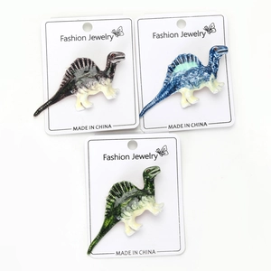 Detail view of colorful cartoon dinosaur brooches in three vibrant gradient enamel colors