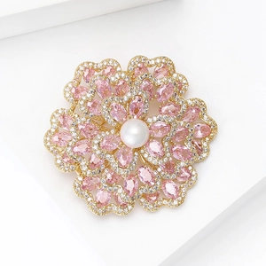 Nahaufnahme der Begonien-Brosche mit rosa Zirkon, weißer Perle und vergoldeter Basis