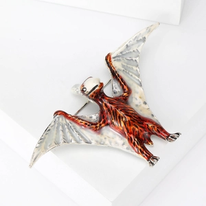 Macro view of pterosaur brooch featuring orange enamel and intricate wing texture details