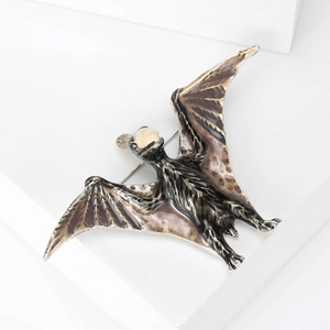 Cute cartoon pterodactyl brooch with vintage enamel finish on a suit jacket