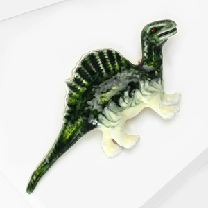 Detail of green marbled dinosaur hair claw clip with red eye accent on white background