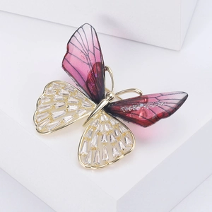Detail of crystal butterfly brooch with pink enamel wings and gold inlaid zircons