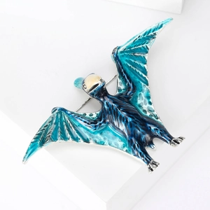 Close-up of a gradient blue and green pterodactyl brooch with sparkling rhinestone details