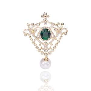 Detail of vintage court brooch with emerald gemstone, white zircon and pearl pendant
