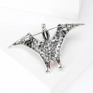 Retro silver alloy pterodactyl brooch with intricate star patterns and red enamel details