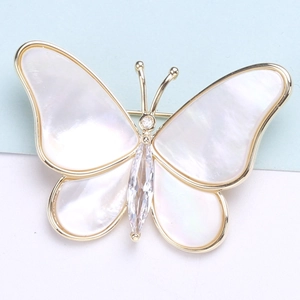 Elegant gold butterfly brooch with natural white shell wings and sparkling zircon stone