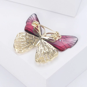 Elegant gold butterfly brooch with purple wings and hollow patterns on white cubes