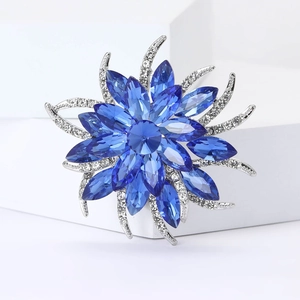 Broche fleur luxueuse avec cristaux bleu foncé et volutes argentées pour costume de femme