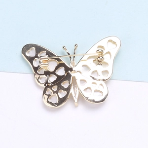 Detailed back view of golden butterfly brooch featuring heart-shaped hollow-out patterns