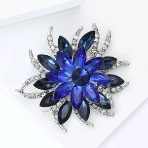 Détail d'une broche fleur en cristal bleu avec base en métal argenté et strass
