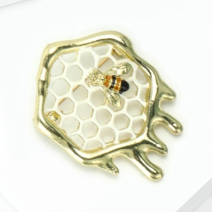Détail de la broche abeille dorée avec insecte émaillé et effet goutte de miel