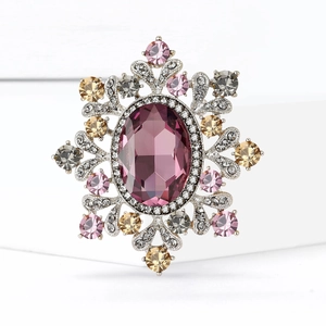 Luxurious vintage-style floral brooch with purple gemstone and crystals on white display
