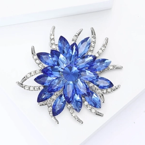 Détail macro d'une broche tournesol en argent avec cristaux bleus et zircons étincelants