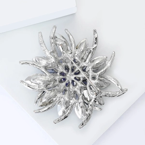 Détails du revers d'une broche fleur en argent avec cristal bleu et fermoir épingle