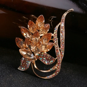 Macro shot of wheat ear brooch with amber crystals and rhinestones on dark leather