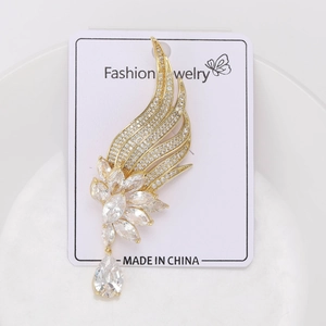 Detailed shot of golden wing floral brooch with zircon inlay and teardrop pendant charm