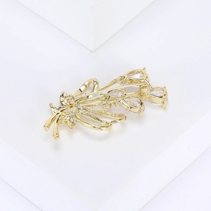 Macro shot of gold floral brooch featuring sparkling crystals and a secure safety pin back