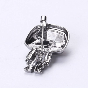 Detail view showing the silver alloy metal brooch back and secure safety pin fastener