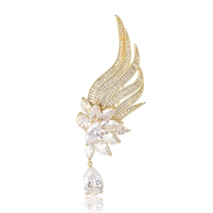 Exquisite gold angel wing brooch with sparkling cubic zirconia stones on white background