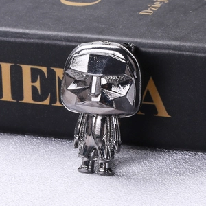 Macro shot of the Frontman geometric mask brooch in black metal finish from Squid Game