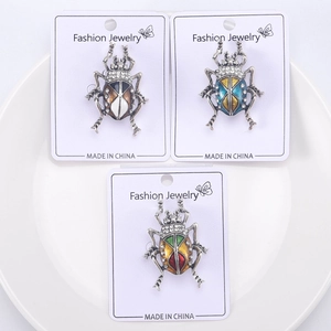 Detailed macro view of beetle brooches with colorful enamel finish and crystal inlay