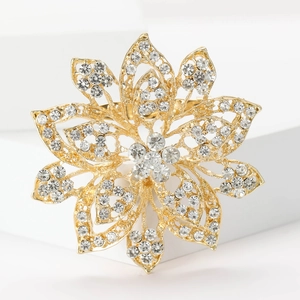 Macro view of gold flower brooch with rhinestone crystals and hollow petal design