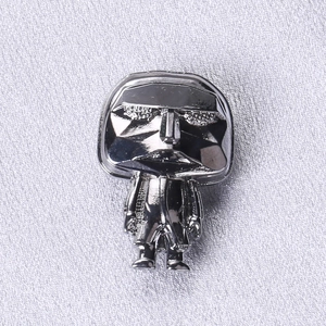 Detail view of Karl Lagerfeld figure brooch in silver polished metal with suit design