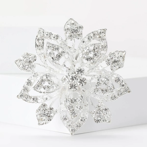 Sparkling silver alloy flower brooch with rhinestones on a minimalist white display