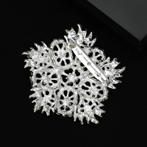 Silver sunflower brooch back view showing safety pin clasp and hollow metal texture