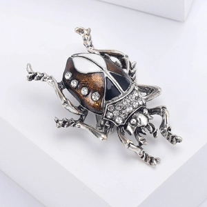 Detailed view of beetle brooch with enamel painting and sparkling white rhinestones