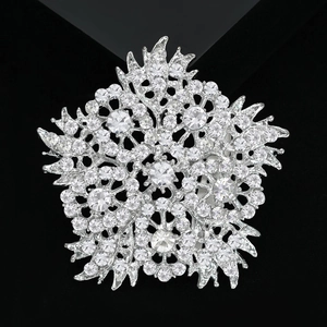 Elegant silver flower brooch with sparkling rhinestones on premium black velvet background