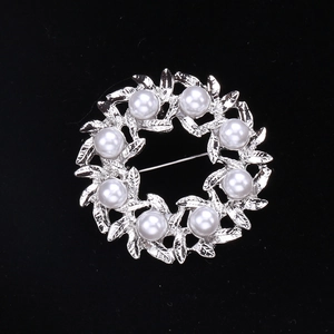 Elegante broche de corona de perlas con hojas de aleación de plata sobre terciopelo negro