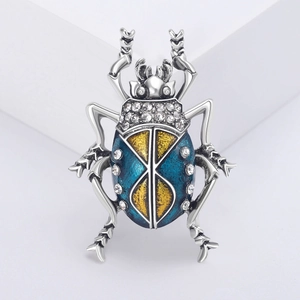 Luxurious blue and yellow enamel beetle brooch with crystals on a minimalist pedestal