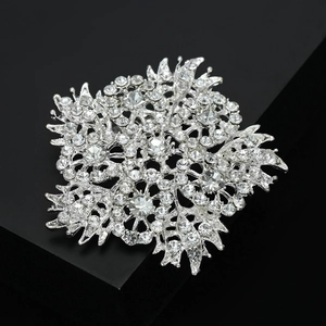 Macro shot of silver plated floral brooch with sparkling rhinestones on black stand