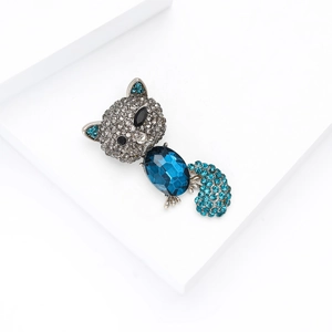 Macro shot of a fox brooch with a large blue oval gemstone and sparkling grey rhinestones