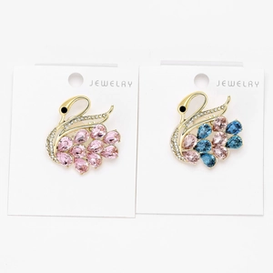 Detailed macro view of crystal swan brooches featuring pink and blue rhinestones